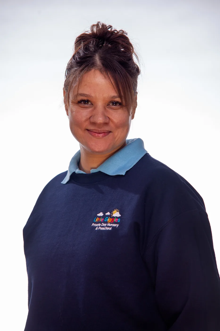 Helena Shelton, smiling, in a navy Little Giggles sweatshirt against a white background