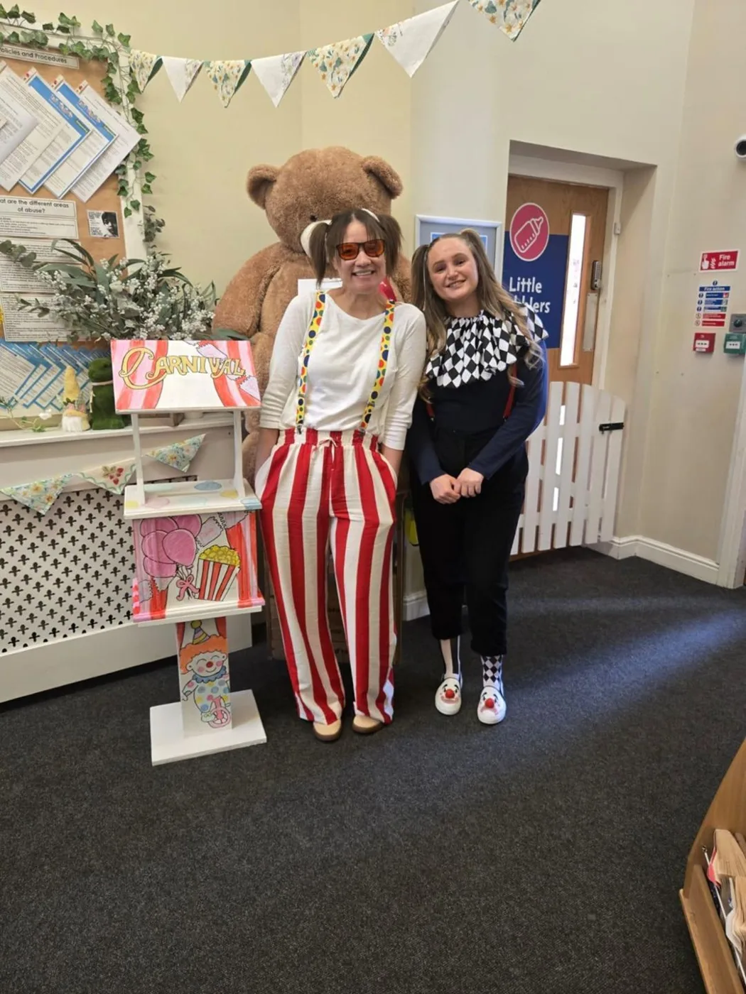 Office manager Sionade Wagstaff and nursery manager Helena Shelton on carnival day, beside the wishing well and the Name the Bear teddy