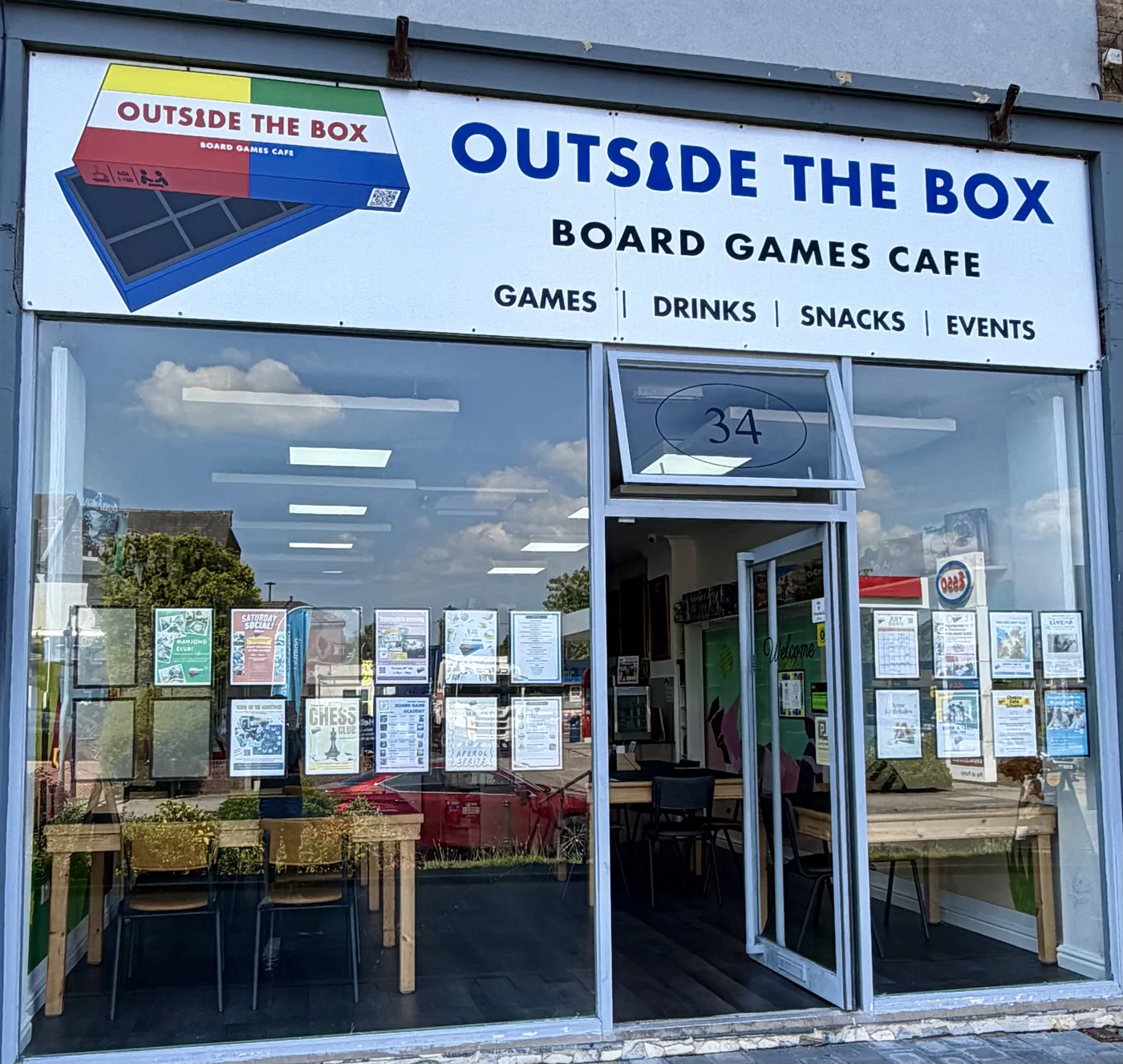 The shopfront of Outside The Box board games café at number 34, with a large sign reading games, drinks, snacks, events